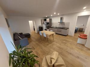 a living room with a table and a kitchen at Appartamento ZUFALL in Cogolo