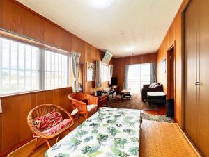 ein Zimmer mit einem Bett und einem Wohnzimmer in der Unterkunft アトムハウス in Okinawa