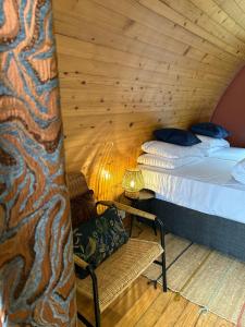 a room with two beds and a chair and a lamp at Revive Wellness Pods in Rostrevor