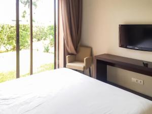 a bedroom with a bed and a tv and a chair at Elegant Villa in Marrakech with a Private Pool. in Douar bel Rhanodour