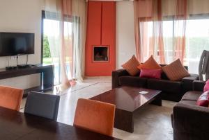 a living room with a couch and a table at Elegant Villa in Marrakech with a Private Pool. in Douar bel Rhanodour +22 photos