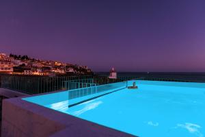 a swimming pool with a view of the ocean at night at Villa Belafonte in Câmara de Lobos