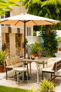 a table and chairs under an umbrella on a patio at Hotel Atithya in Udaipur +28 photos