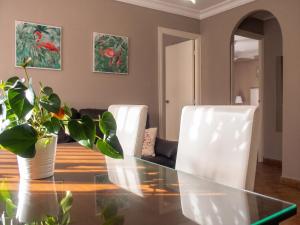 a dining room with a glass table and white chairs at Comfortable Apartment Ayamonte Garden in Ayamonte