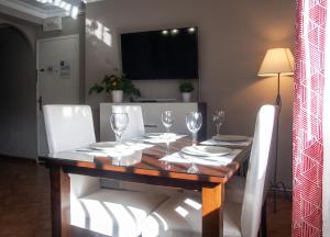 a dining room table with white chairs and a television at Comfortable Apartment Ayamonte Garden in Ayamonte