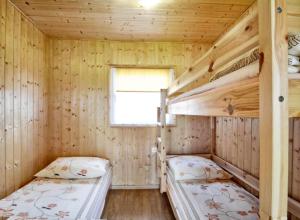 two bunk beds in a wooden cabin with a window at Pelikan in Sianozety