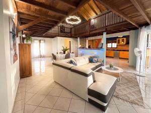 a living room with a couch and a table at Maison conviviale à Deshaies avec piscine partagée 120 m² in Deshaies