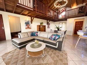 a living room with a couch and a table at Maison conviviale à Deshaies avec piscine partagée 120 m² in Deshaies
