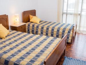 a bedroom with two beds and a lamp on a table at Sea View Apartment in Peniche in Peniche