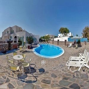 a swimming pool with chairs and a table and a patio at Babis Hotel in Karterados