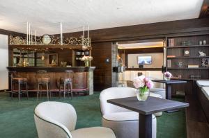 a room with a bar with chairs and a table at Bartl Apartments in Rottach-Egern