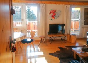 a living room with a television and a table and chairs at Spacious Apartment in Lens with Mountain View in Lens