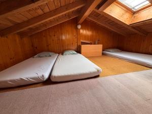 two beds in a room with wooden walls and ceilings at Malgré tout 2 in Salvan
