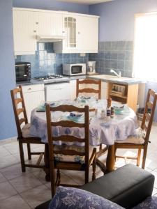 a kitchen with a table and two chairs and a table and a kitchen at Appartement avec piscine partagée à Roquefort-la-Bédoule - 50m² in Roquefort-la-Bédoule