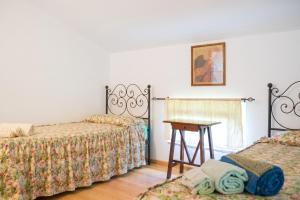 a room with two beds and a table in it at Comfortable Apartment in Fabriano, 35 m² with Shared Pool in Fabriano