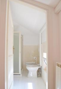 a white bathroom with a toilet and a sink at Comfortable Apartment in Fabriano, 35 m² with Shared Pool in Fabriano +13 photos