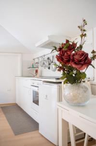 a white kitchen with a vase of roses on a table at Comfortable Apartment in Fabriano, 35 m² with Shared Pool in Fabriano