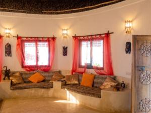 a living room with red curtains and a couch at Spacious accessible house in Watamu, shared pool in Watamu