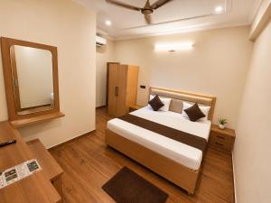 a hotel room with a bed and a mirror at Hotel Param INN in Gwalior +4 photos