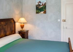 a bedroom with a bed and a lamp on a table at Maison charmante à Chirens avec jardin clôturé in Chirens