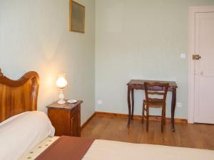 a bedroom with a table and a chair next to a bed at Maison charmante à Chirens avec jardin clôturé in Chirens
