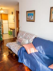 a couch in a living room with a bluesheet at Charming Apartment in El Grove, Sea View in O Grove