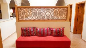 a red couch with two red pillows in a room at Charming Villa in Tou Ganaou with Private Pool in Ti nʼ Saïd