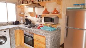 a kitchen with a refrigerator and a microwave at Charming Villa in Tou Ganaou with Private Pool in Ti nʼ Saïd
