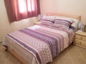 a bedroom with a bed with a purple comforter at Charming Villa in Tou Ganaou with Private Pool in Ti nʼ Saïd