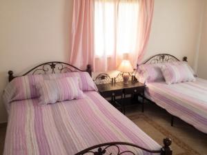 two beds in a bedroom with a desk and a window at Charming Villa in Tou Ganaou with Private Pool in Ti nʼ Saïd