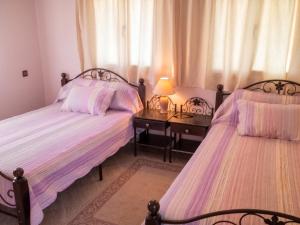 a bedroom with two beds and a table with a lamp at Charming Villa in Tou Ganaou with Private Pool in Ti nʼ Saïd +22 photos