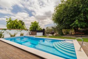 a swimming pool with stairs next to a yard at Quinta da Amora in Quinta do Anjo