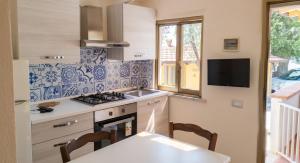 a kitchen with blue and white tiles on the wall at Charming Apartment in Pisciotta with Terrace and Parking in Pisciotta
