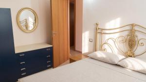 a bedroom with a bed with a mirror and a dresser at Charming Apartment in Pisciotta with Terrace and Parking in Pisciotta