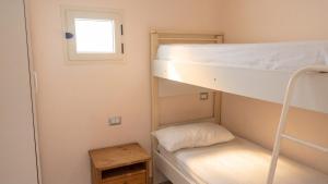a small room with two bunk beds and a window at Charming Apartment in Pisciotta with Terrace and Parking in Pisciotta
