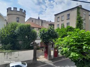 a street with a building with a castle in the background at Chambres d'hôtes de charme "La Tour Richelieu" in Martres-de-Veyre