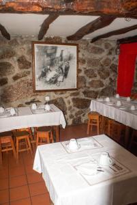 a restaurant with white tables and chairs and a picture at Comfortable Apartment in Seia with Terrace and Fireplace in Seia