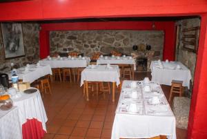 a restaurant with white tables and chairs and red walls at Comfortable Apartment in Seia with Terrace and Fireplace in Seia