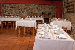 a dining room with white tables and chairs and a fireplace at Comfortable Apartment in Seia with Terrace and Fireplace in Seia