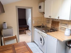 a kitchen with a sink and a washing machine at Appartement charmant à Roanne, terrasse in Roanne