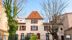 an old house with a tile roof and a fence at Appartement charmant à Roanne, terrasse in Roanne
