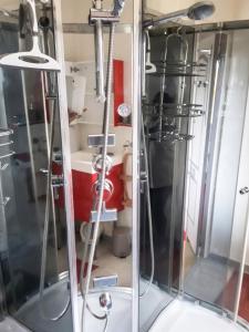 a shower in a bathroom with a red sink at Appartement cosy aux Authieux Papion 15 m² avec jardin privatif in Les Authieux-Papion