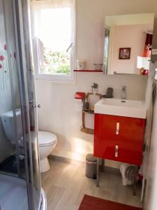 a bathroom with a sink and a toilet and a window at Appartement cosy aux Authieux Papion 15 m² avec jardin privatif in Les Authieux-Papion
