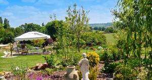a garden with a statue in the middle at Appartement cosy aux Authieux Papion 15 m² avec jardin privatif in Les Authieux-Papion