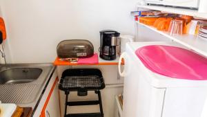 a small kitchen with a sink and a pink counter at Studio charmant à Sainte-Anne avec piscine privée, 25 m² in Sainte-Anne