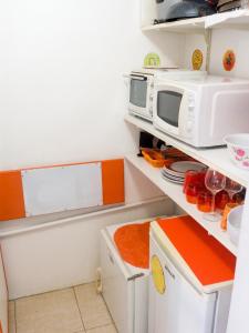 a kitchen with a microwave and a refrigerator at Studio charmant à Sainte-Anne avec piscine privée, 25 m² in Sainte-Anne