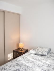 a bedroom with a bed and a lamp on a nightstand at Appartement avec vue sur mer à Port-Vendres, 60 m², balcons. in Port-Vendres