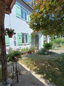 a house with green shutters and plants in a yard at Studio im Krater in Wallerstein