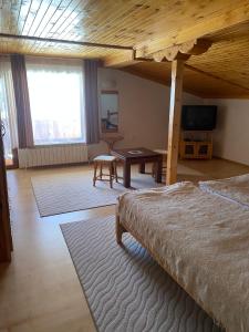a bedroom with a bed and a table in a room at Family Hotel Markony in Pamporovo