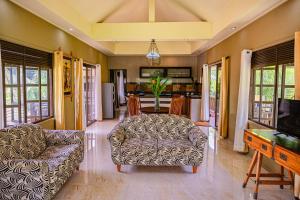 a living room with a couch and a table at Villas des Alizes Beachfront Suites in Grand'Anse Praslin
